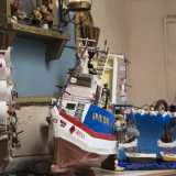 L�artigiano ci mostra alcune delle sue creazioni. Tra queste un grande peschereccio sulla cui prua � scritto in rosso il nome �Grecale�, il veliero �Stella Maris�...